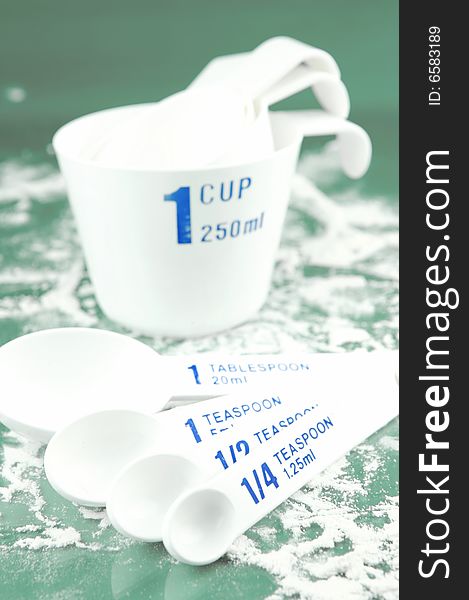 Measuring cups and spoons isolated against a green background. Measuring cups and spoons isolated against a green background