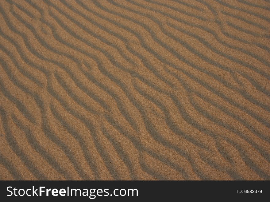 Sand shaped into pattern from wind and water. Sand shaped into pattern from wind and water