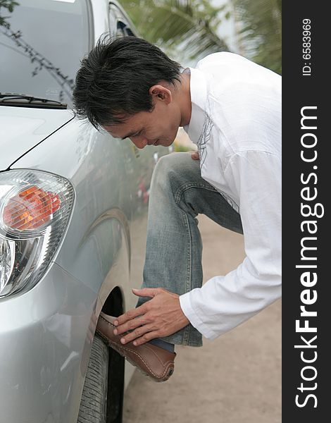 Man cleaning the shoes on car wheel. Man cleaning the shoes on car wheel