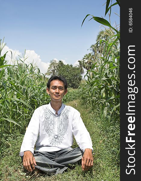 Man sitting in corn farm. Man sitting in corn farm