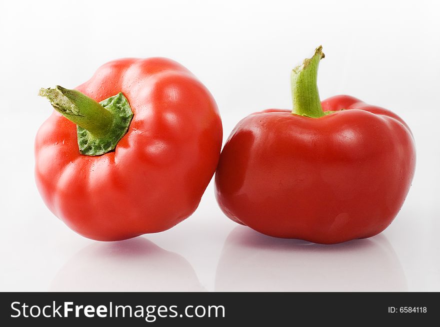 Red bell peppers on white background with reflection