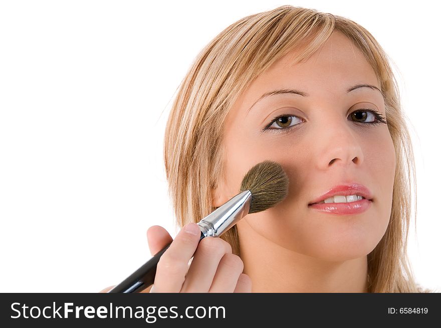 Pretty young woman applying make up. Isolated on white background