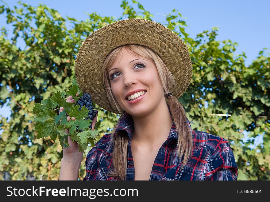 Closeup portrait of a happy young peasant woman among the vineyards