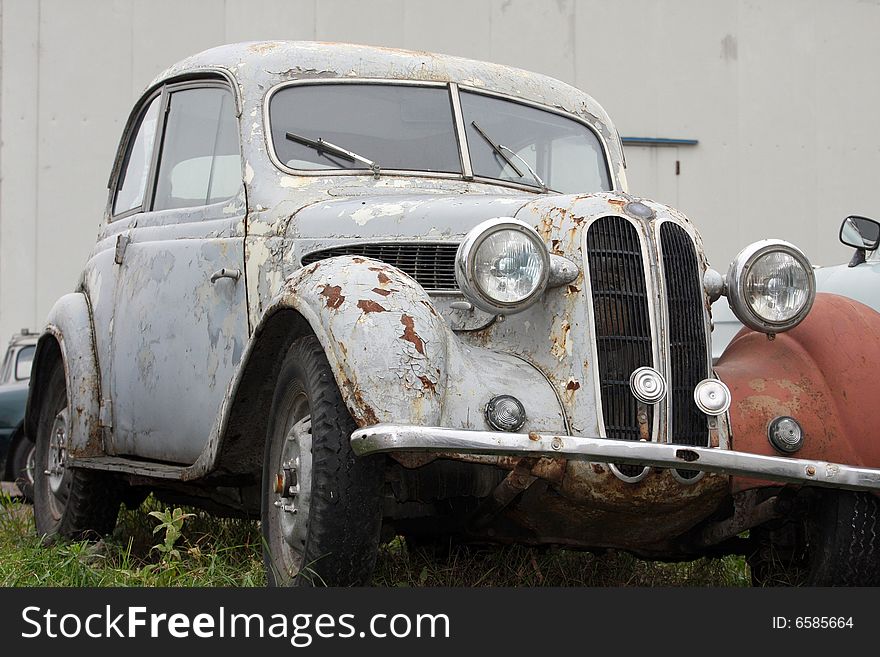 The old automobile stands in the street in autumn, weather rainy. The old automobile stands in the street in autumn, weather rainy