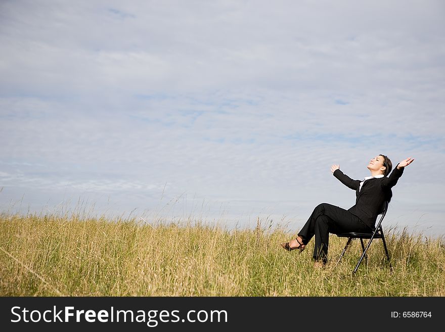 Attractive brunette businesswoman relaxing on meadow. Attractive brunette businesswoman relaxing on meadow
