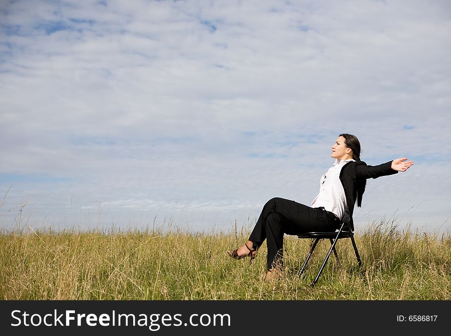 Attractive brunette businesswoman relaxing on meadow. Attractive brunette businesswoman relaxing on meadow