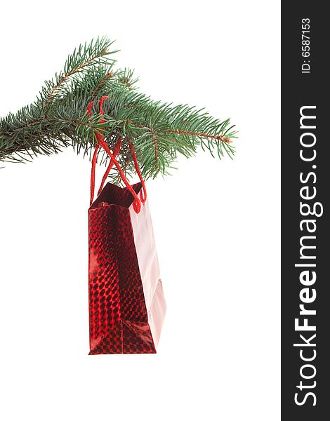 Red gift bag hanging on a fir-tree branch, isolated. Red gift bag hanging on a fir-tree branch, isolated