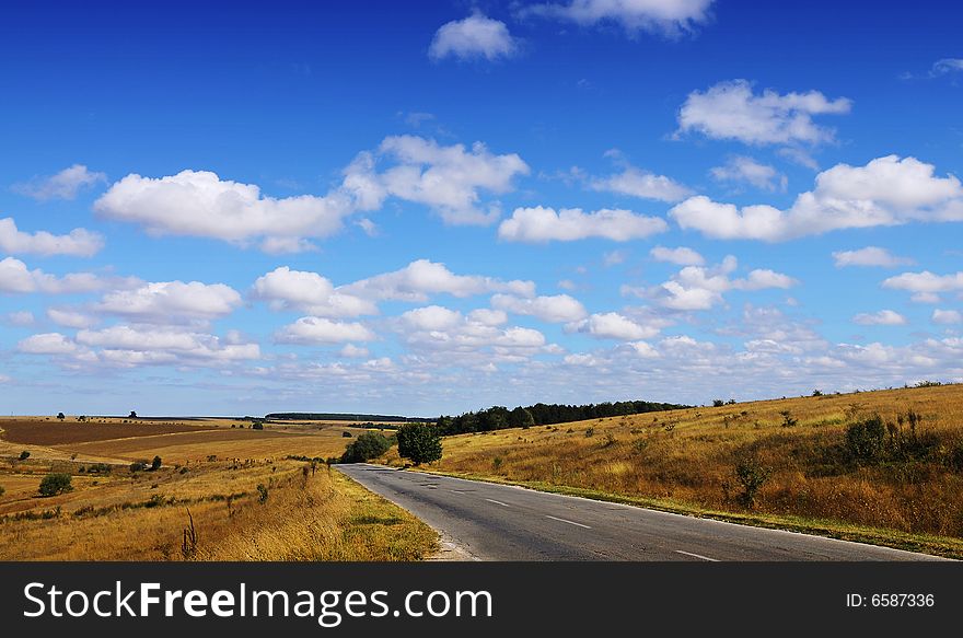 Autumn landscape with road and cloudy sky