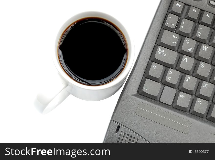 Coffee cup besides a laptop isolated on white. Coffee cup besides a laptop isolated on white