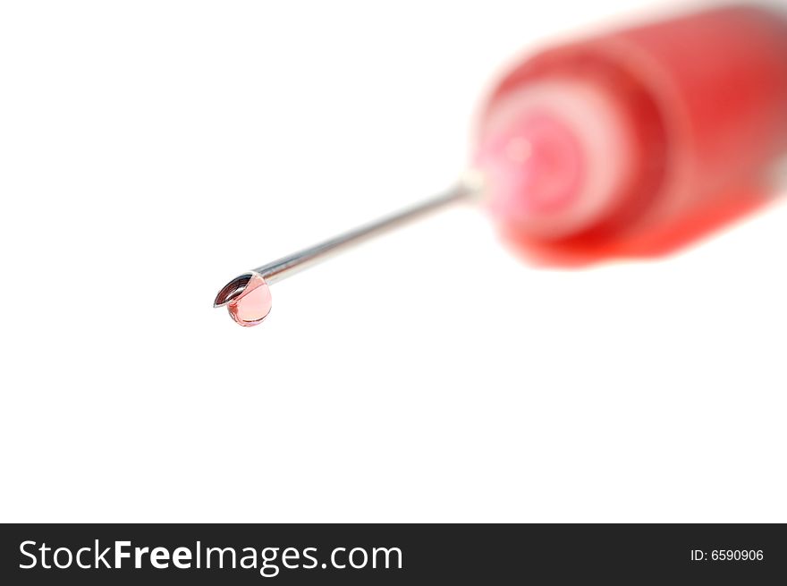 Drop on the tip of a syringe needle