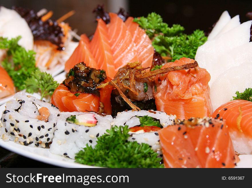 Decorated dish of seafood, with sushi, sashimi, lobster, shrimp. Decorated dish of seafood, with sushi, sashimi, lobster, shrimp