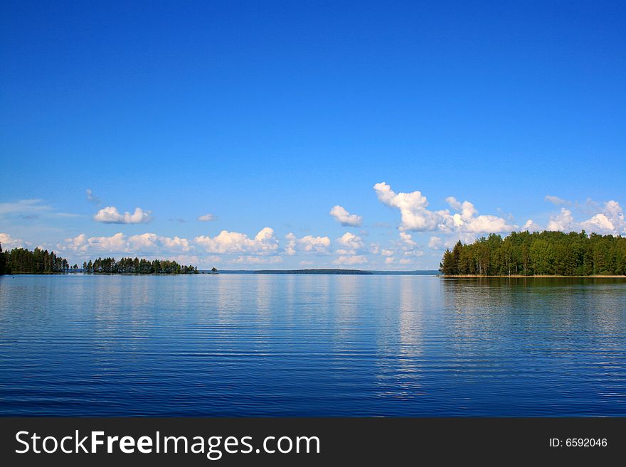 Calm lake and bright blue sky with clouds. Calm lake and bright blue sky with clouds