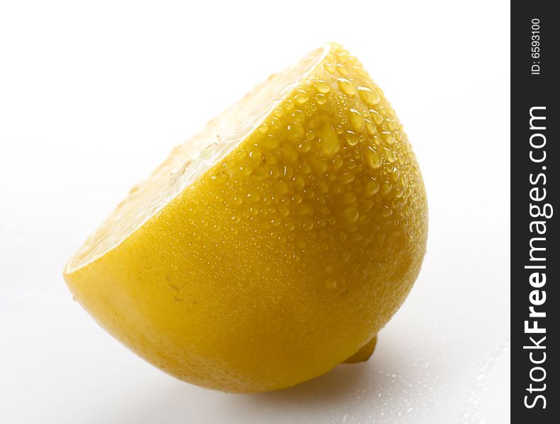 Sliced lemon with water drops on grey