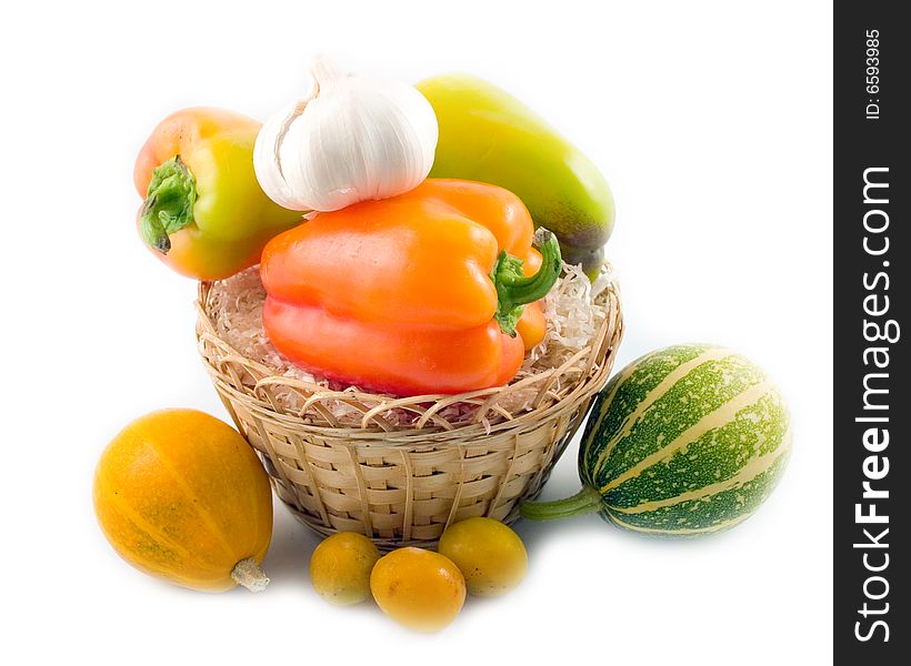 Plum sweet beautiful pepper garlic decorative pumpkins in basket on white background