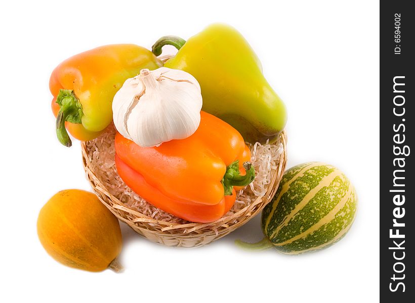 Sweet beautiful pepper garlic decorative pumpkins in basket on white background