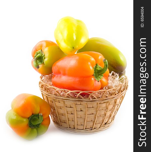 Red green yellow sweet beautiful pepper in basket on white background