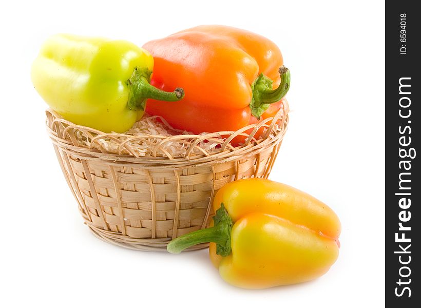 Red green yellow sweet beautiful pepper in basket on white background