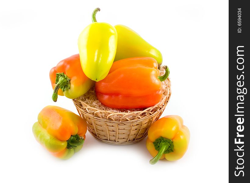 Red green yellow sweet beautiful pepper in basket on white background