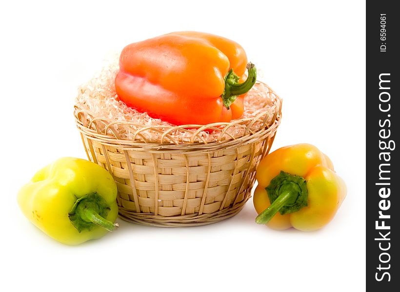 Red green yellow sweet beautiful pepper in basket on white background