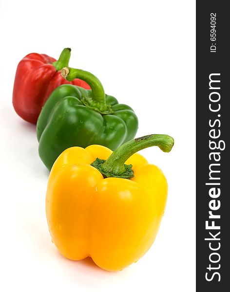 Red, green and yellow bell peppers isolated on white.