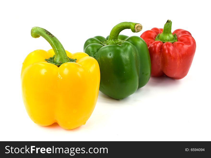 Red, green and yellow bell peppers isolated on white.
