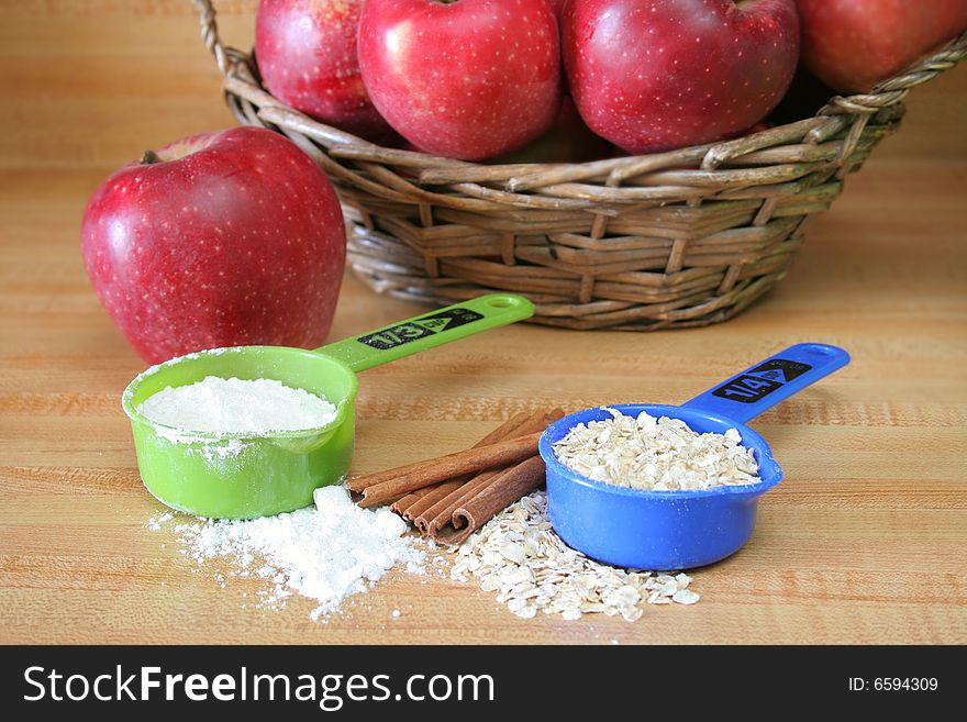 Ingrediants to make an homemade apple crisp. Flour, oats, cinnamon and fresh apples.