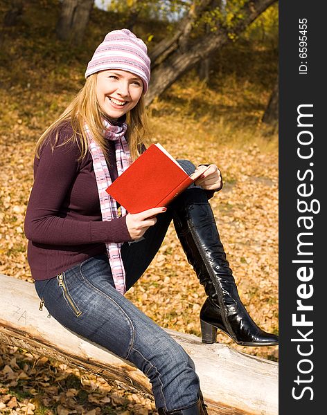 Pretty girl reading a book in the park