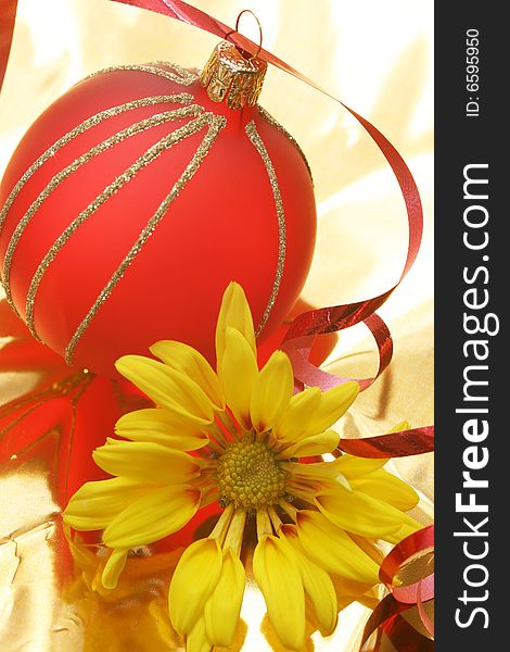 Christmas red ball with yellow flower on golden background. Christmas red ball with yellow flower on golden background.