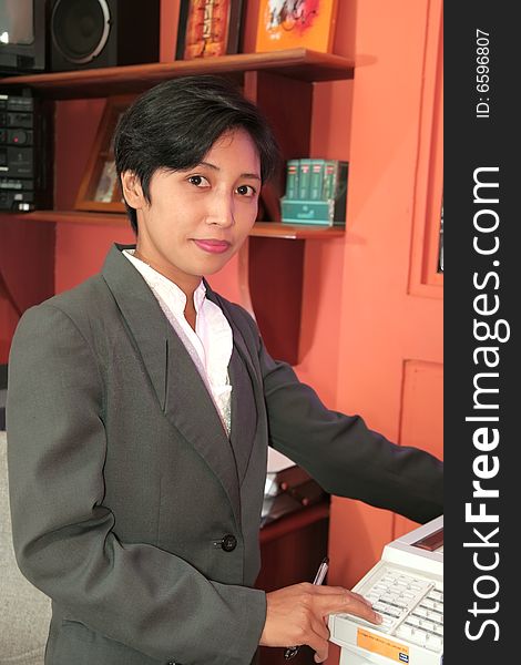 Photograph of secretary at office holding photo copy machine