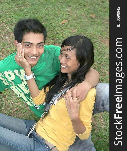 Happy young asian couple on grass