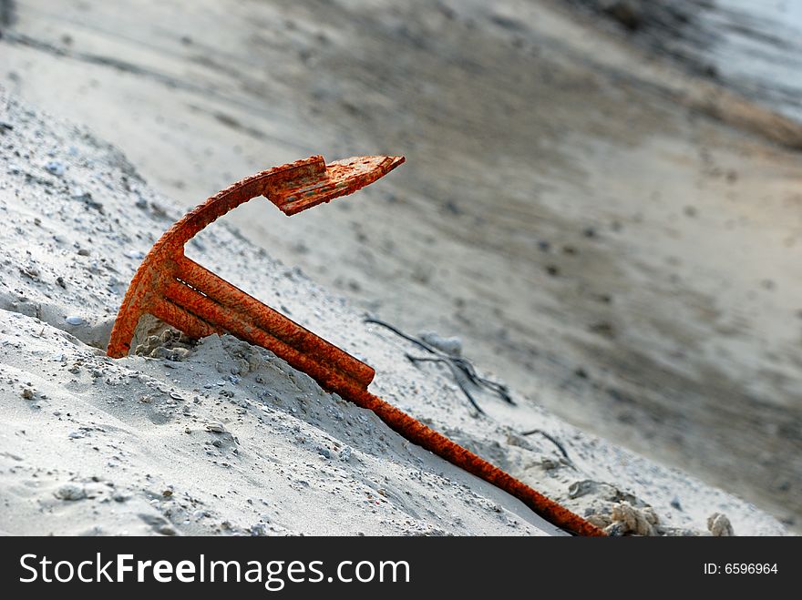 An rusty anchor isolated on beach. An rusty anchor isolated on beach