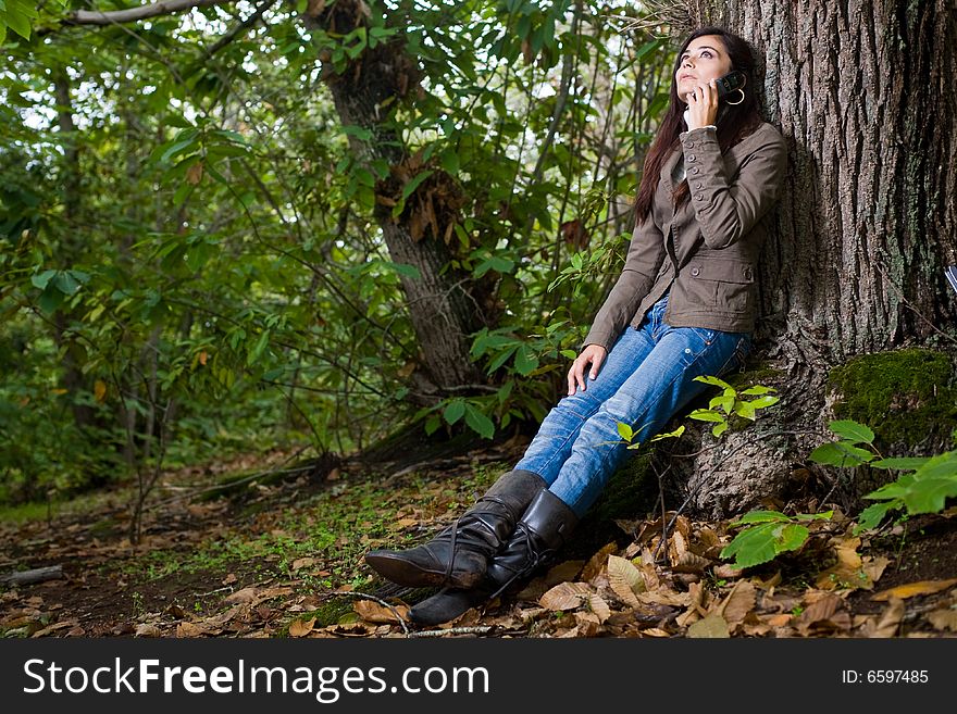Young woman talking by phone on deep forest. Young woman talking by phone on deep forest