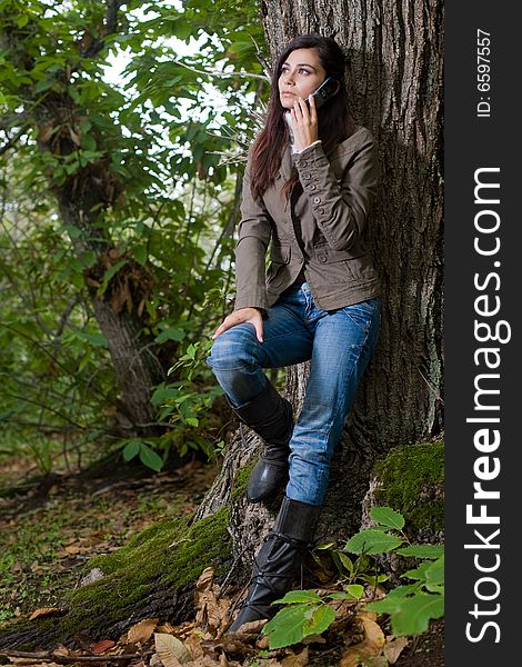 Young woman talking by phone on deep forest. Young woman talking by phone on deep forest