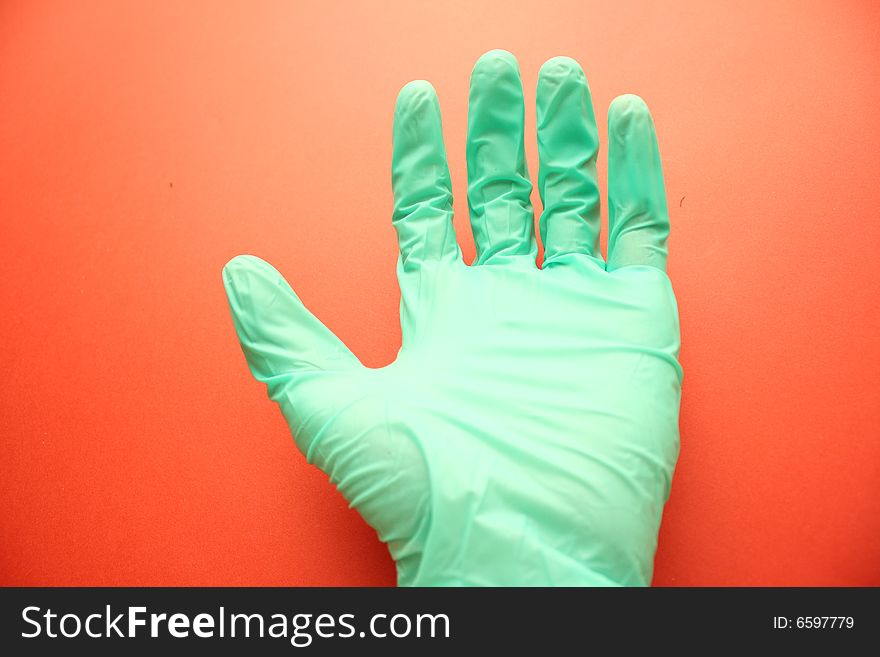 Extended arm in the green rubber glove on the background. Extended arm in the green rubber glove on the background