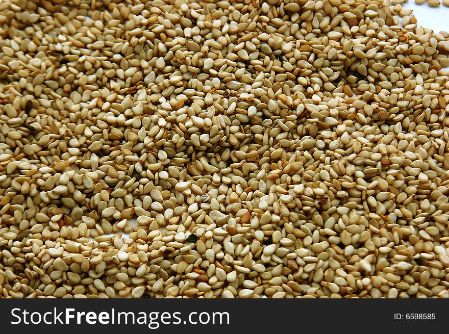 Many sesame seeds on background