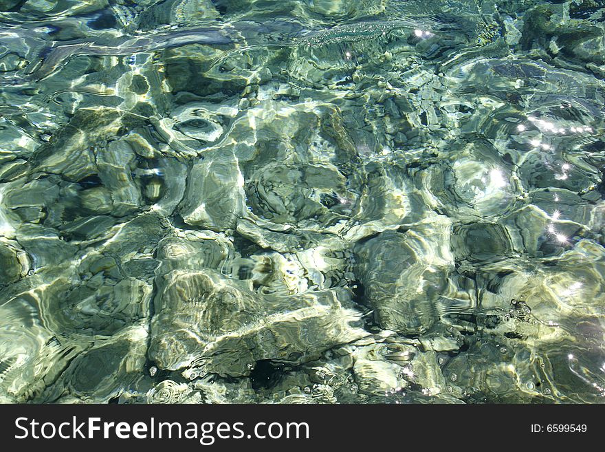 Sea water reflection and pebbles