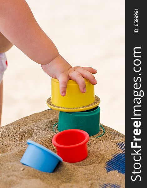 Children's hand and toys on sand. Children's hand and toys on sand