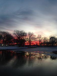 Sunset In A Park With Ice On Frozen Pond In Winter. Royalty Free Stock Image