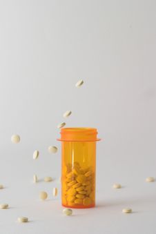 Pills Falling Into And Around Medicine Bottle Version 3 Royalty Free Stock Images