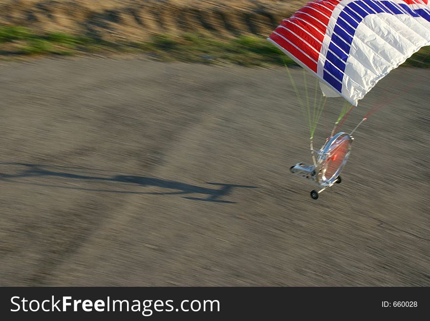 Snapshot of a model paraglider during take-off. Focus is on the wing.