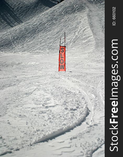 This is an orange sign you see on a ski slope. It is made of a see-through mesh material. Obviously used to caution skiiers to slow down. This is an orange sign you see on a ski slope. It is made of a see-through mesh material. Obviously used to caution skiiers to slow down.