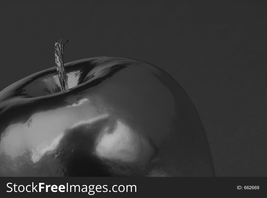 A metallic apple against a silver background. A metallic apple against a silver background.