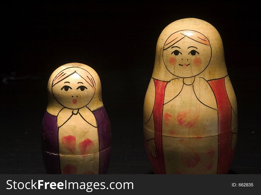 Two happy wodden dolls on a black background. Two happy wodden dolls on a black background