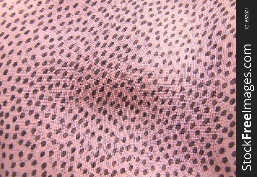 Pink fabric with regular brownish printed dots. Pink fabric with regular brownish printed dots