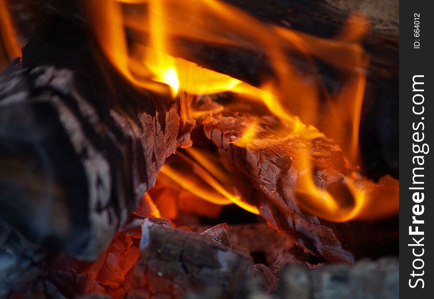 Flames and embers from a burning fire inside of a chimnea. Flames and embers from a burning fire inside of a chimnea.