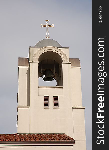 Church steeple, with gold cross and bell.