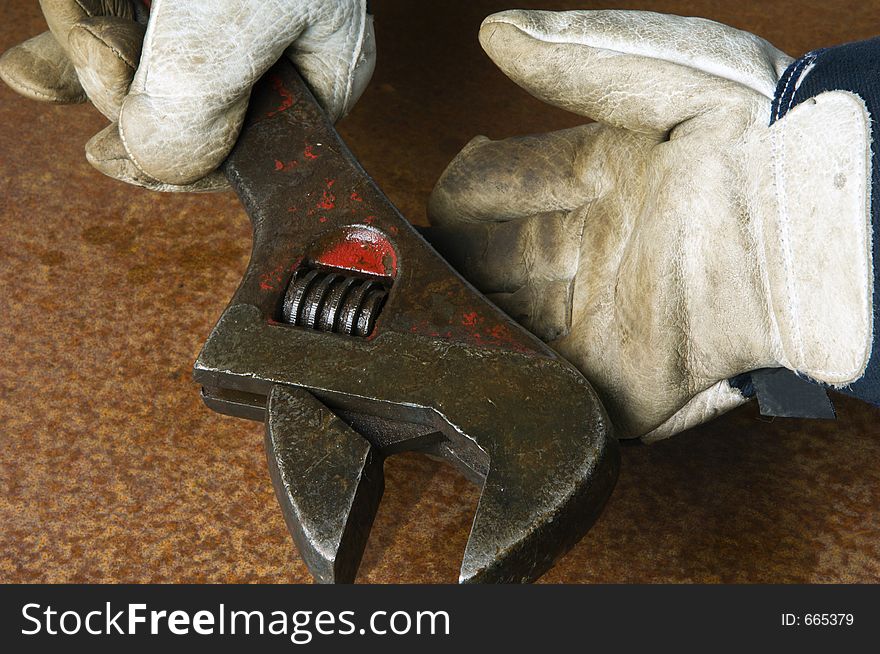 Working gloves handing large wrench. Working gloves handing large wrench