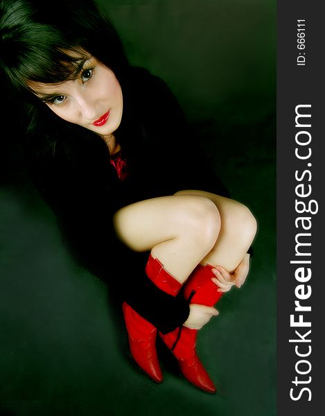 Wide angle shot of woman in red boots, accent on the face. Wide angle shot of woman in red boots, accent on the face