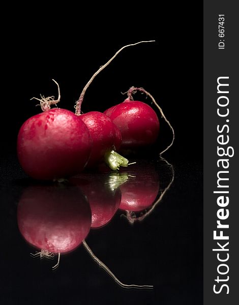 Three red radishs on the black background