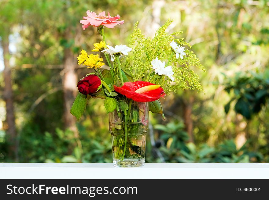Bouquet from different flowers on a table on a background of the nature
